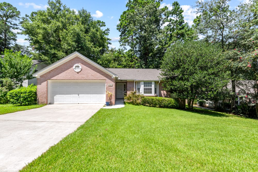 Brick house exterior with two-car garage and green lawn